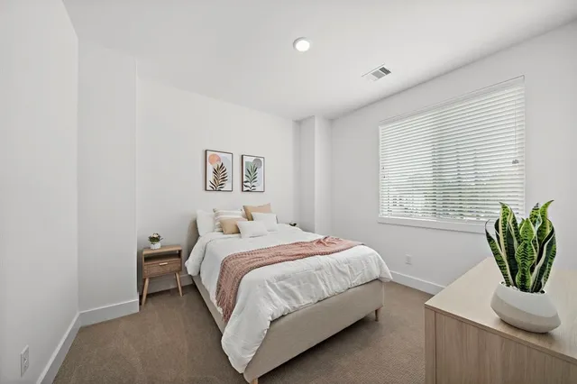 a bedroom with a bed and a potted plant