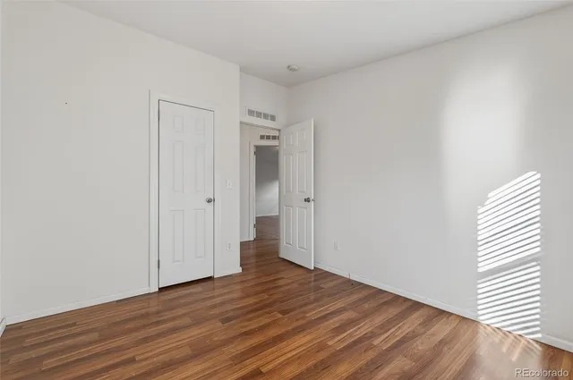 a view of a room with wooden floor and white doors