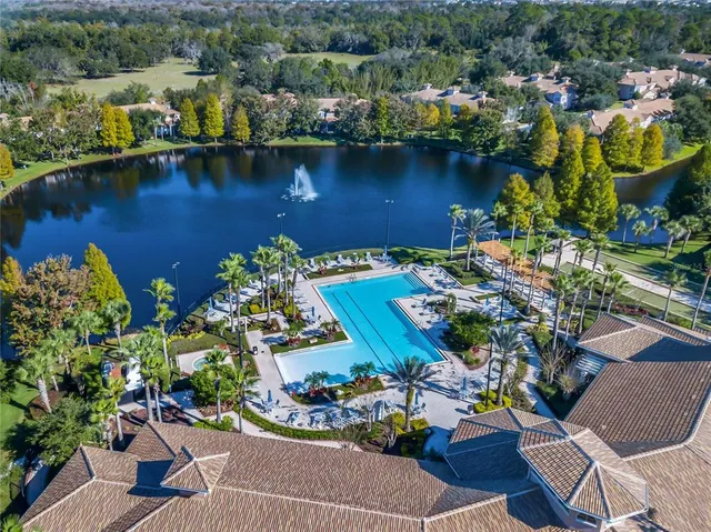 an aerial view of residential houses with outdoor space and a lake view