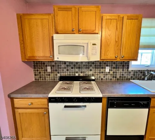 a bathroom with a sink a refrigerator and a window