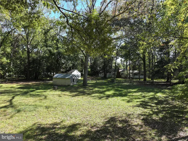 a white wall with a white comforter and a painting on it