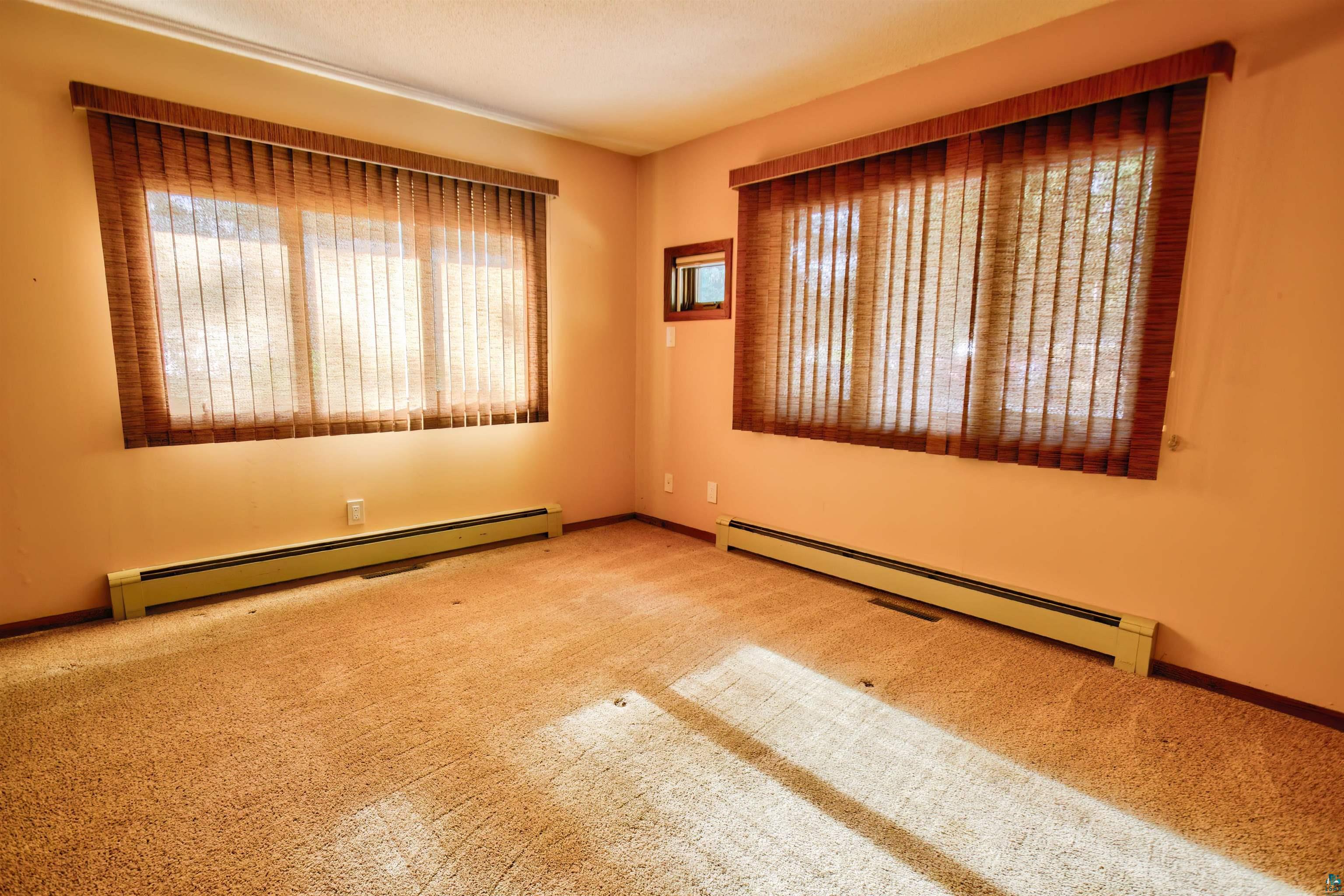1933 West Shagawa Road Ely, MN 55731 - Photo 17 of 46 Carpeted spare room featuring a baseboard heating unit and a healthy amount of sunlight
