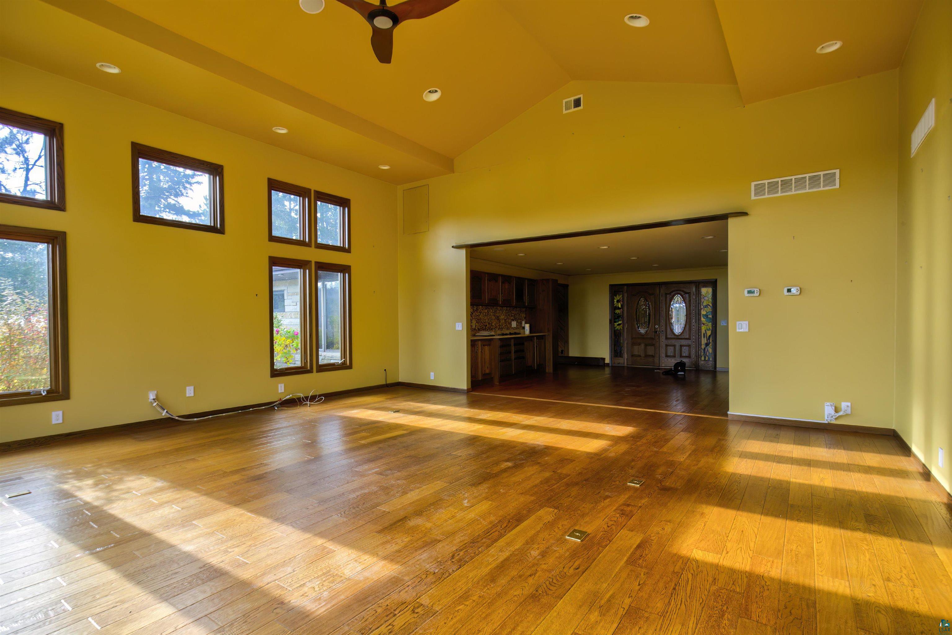 1933 West Shagawa Road Ely, MN 55731 - Photo 3 of 46 Unfurnished living room with hardwood / wood-style floors, high vaulted ceiling, and ceiling fan