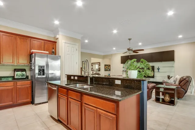 a kitchen with stainless steel appliances granite countertop a sink dishwasher stove and cabinets with wooden floor