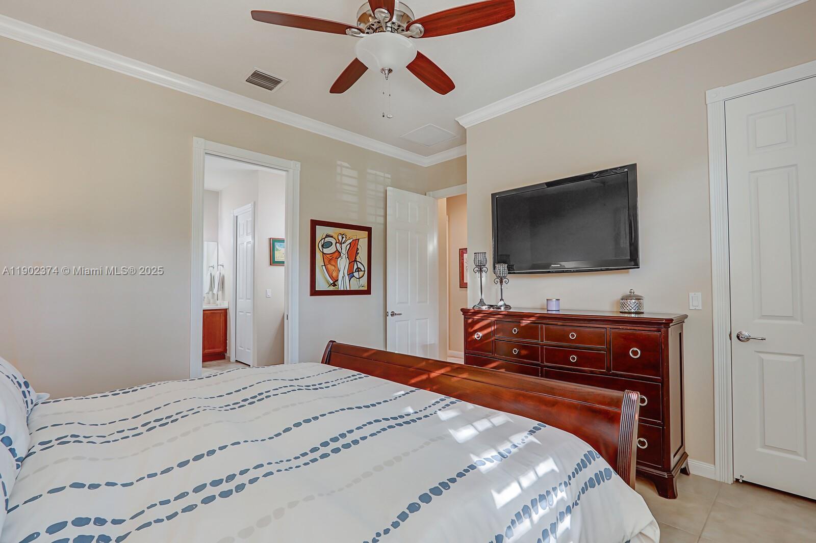 1053 Big Pine Way Jupiter, FL 33458 - Photo 25 of 48 a bedroom with a bed and a flat screen tv