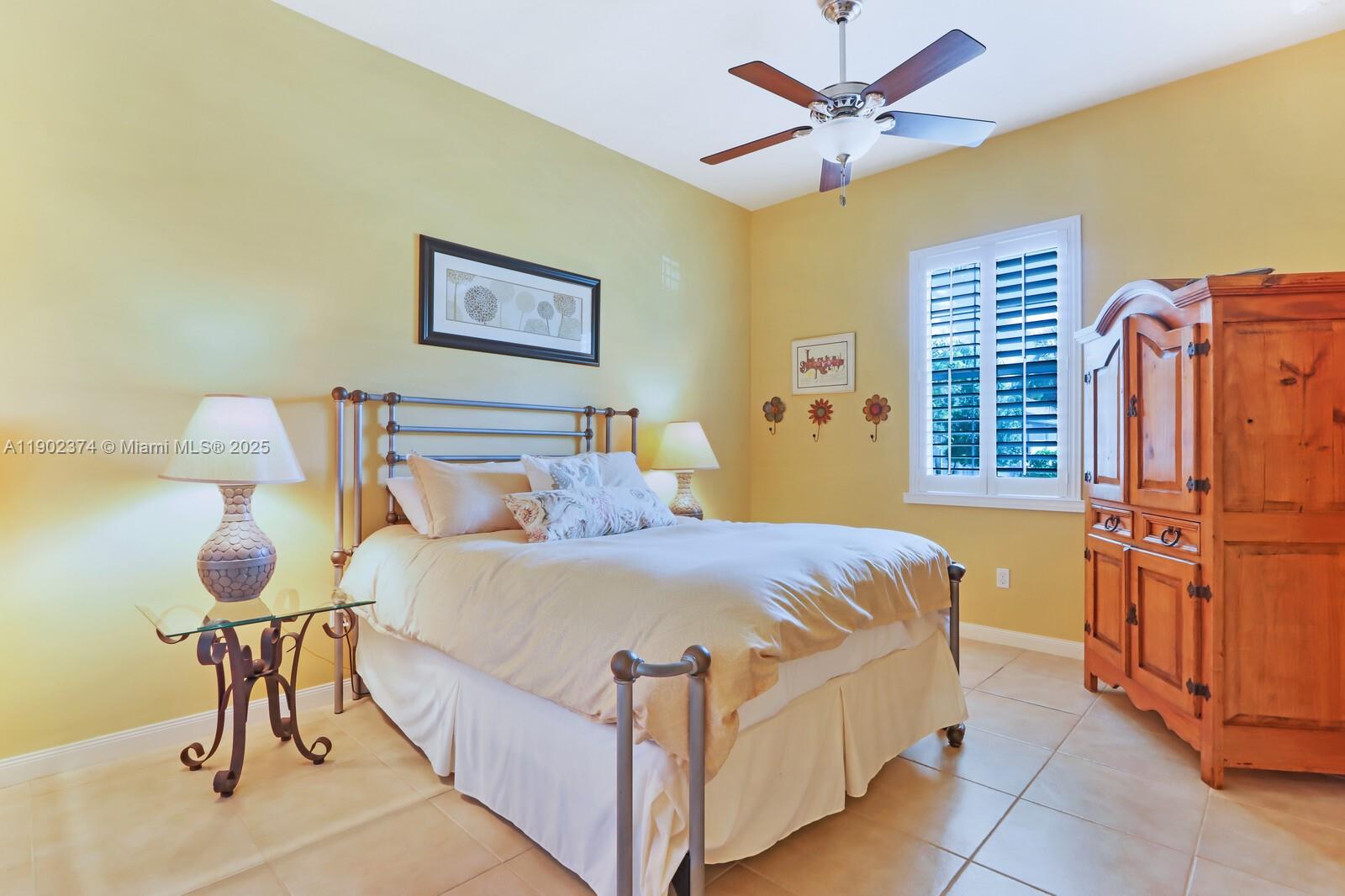 1053 Big Pine Way Jupiter, FL 33458 - Photo 29 of 48 a bedroom with a bed and a chandelier