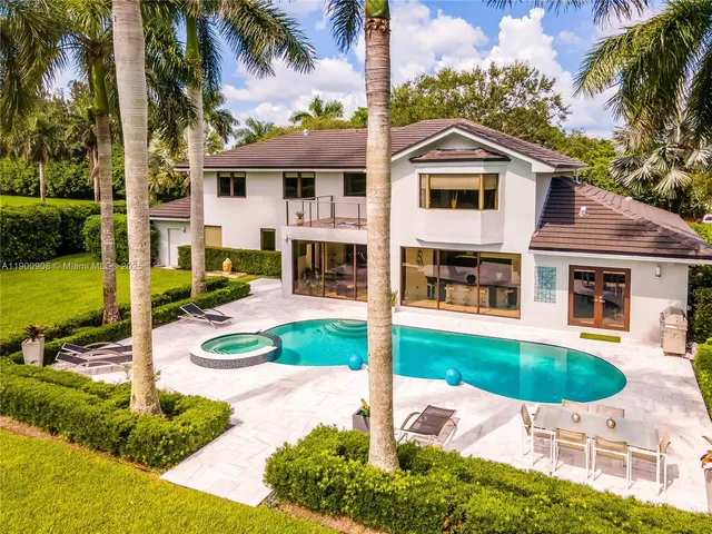 a view of a house with backyard and sitting area