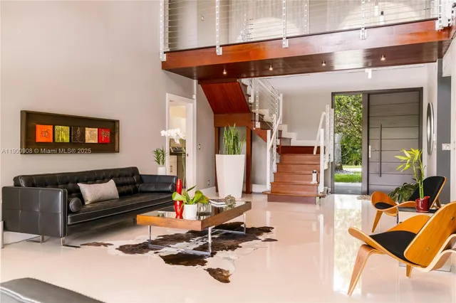 a living room with furniture a wooden floor and next to a window