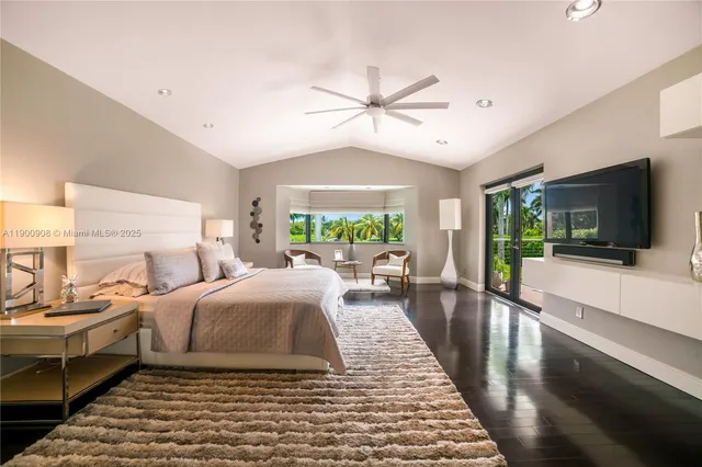 a living room with a bed furniture flat screen tv and a large window