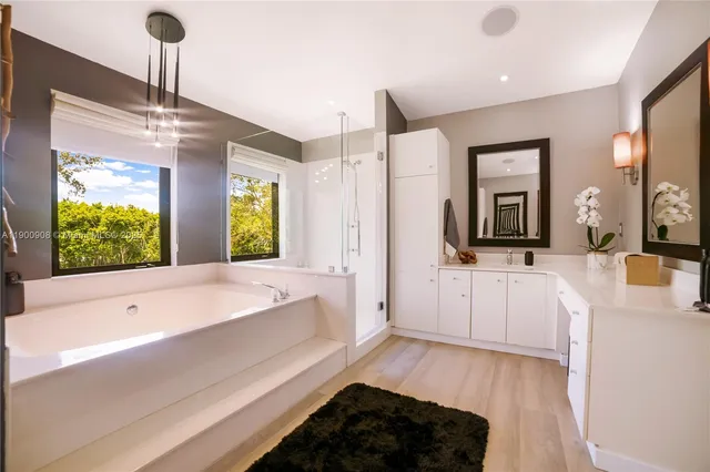 a bathroom with a sink a large mirror and a bathtub