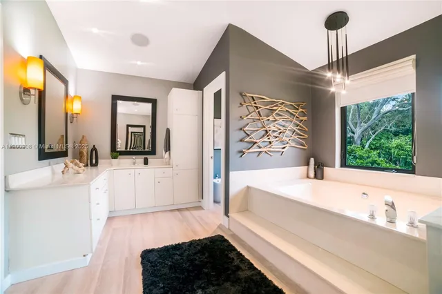 a spacious bathroom with a double vanity sink a large mirror and a bathtub