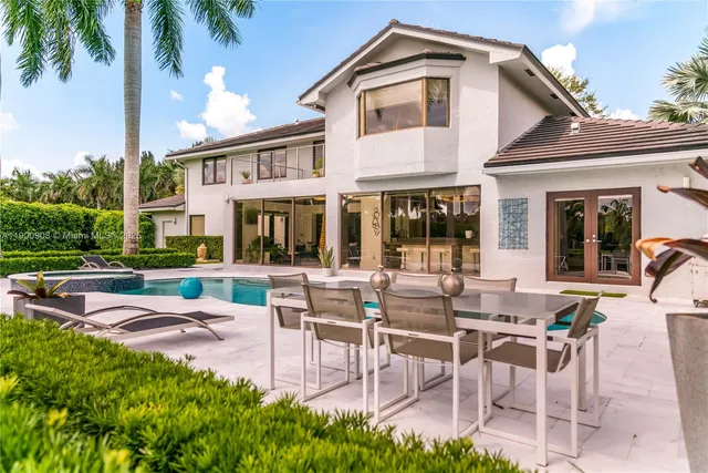 a view of a patio with table and chairs potted plants and palm tree