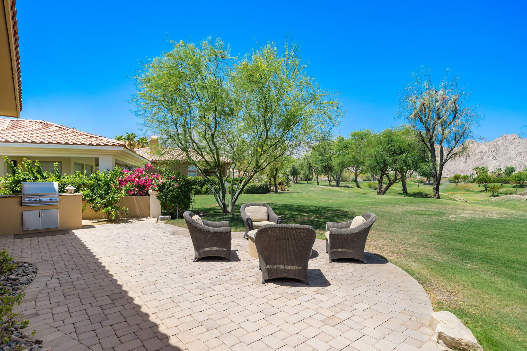 57355 Interlachen La Quinta, CA 92253 - Photo 31 of 35 a view of a patio with table and chairs potted plants and a large tree