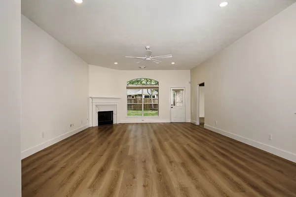 a view of a kitchen with wooden floor and a window