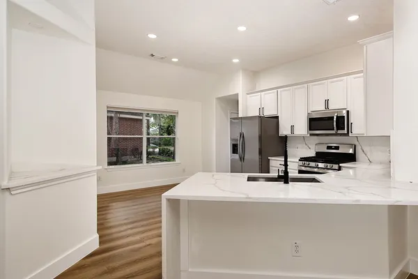 a kitchen with stainless steel appliances a microwave a sink and a refrigerator