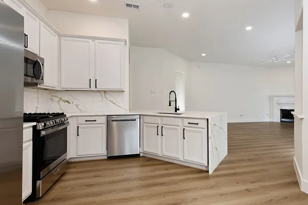 a kitchen with stainless steel appliances granite countertop a stove and a sink