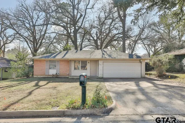 a front view of house with yard and trees
