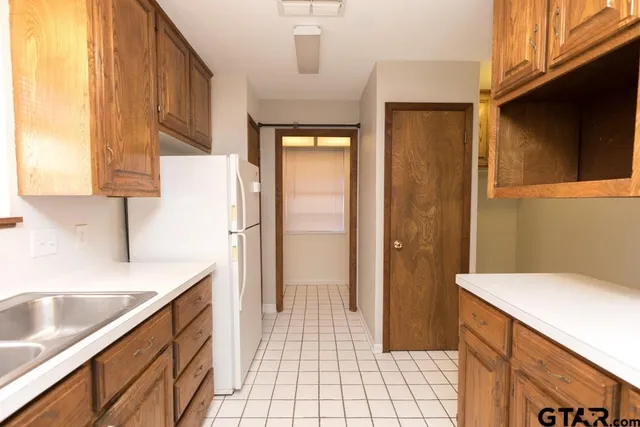 a kitchen with a sink a refrigerator and cabinets