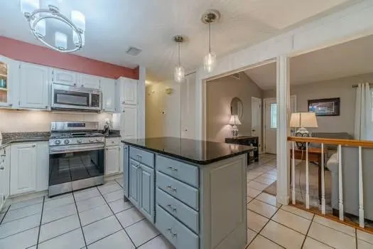 a kitchen with stainless steel appliances kitchen island granite countertop a sink and cabinets