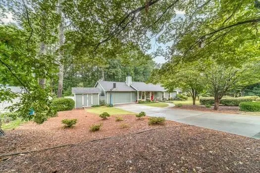 a front view of a house with a yard and trees