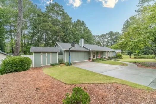 a front view of a house with a garden and yard