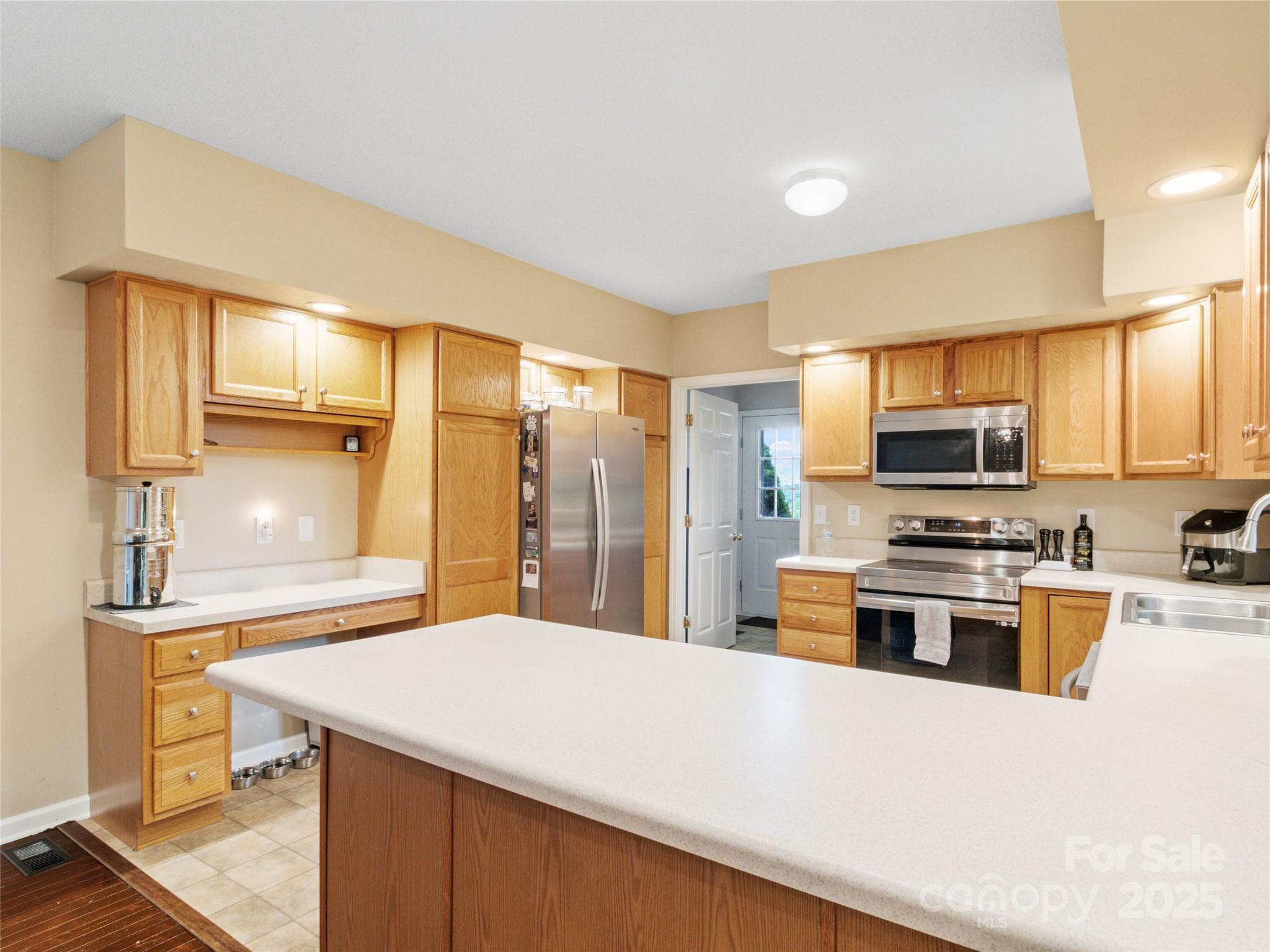 161 Blue Rock Road Burnsville, NC 28714 - Photo 15 of 48 a kitchen with stainless steel appliances a stove refrigerator sink and microwave