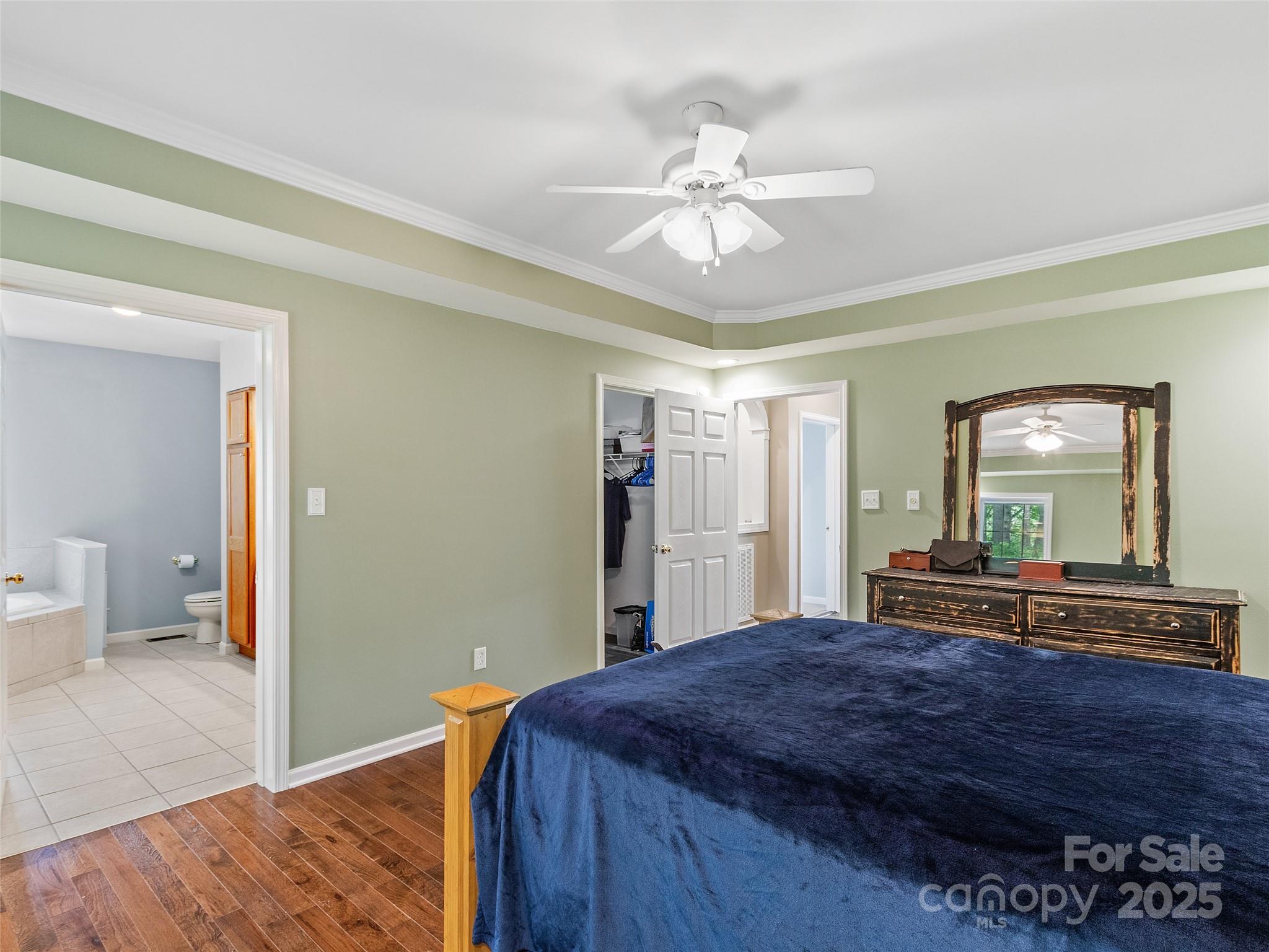 161 Blue Rock Road Burnsville, NC 28714 - Photo 20 of 48 a bedroom with a large bed and a chandelier