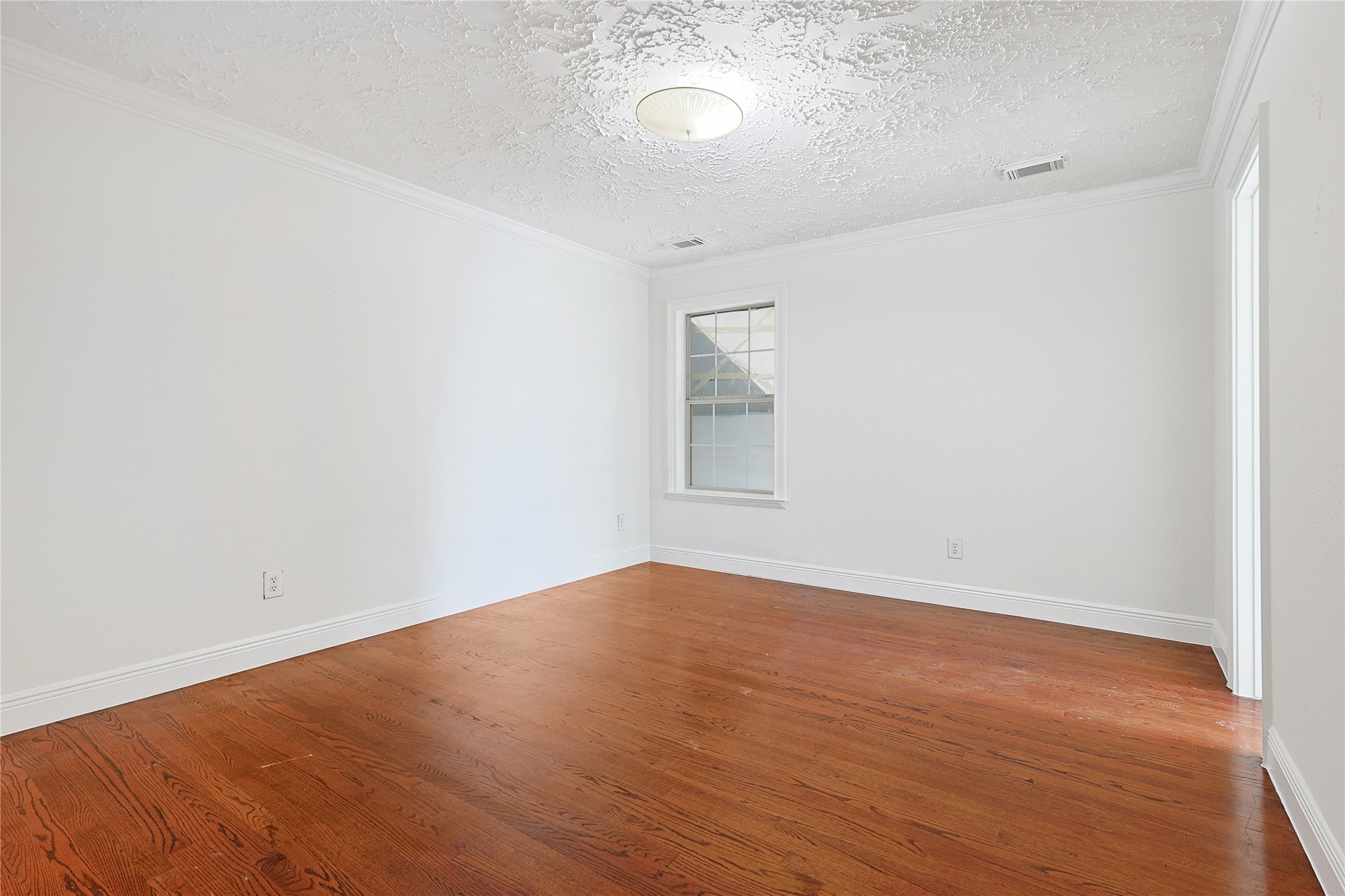 8502 Detroit Street, Unit C Houston, TX 77017 - Photo 13 of 15 an empty room with wooden floor and windows
