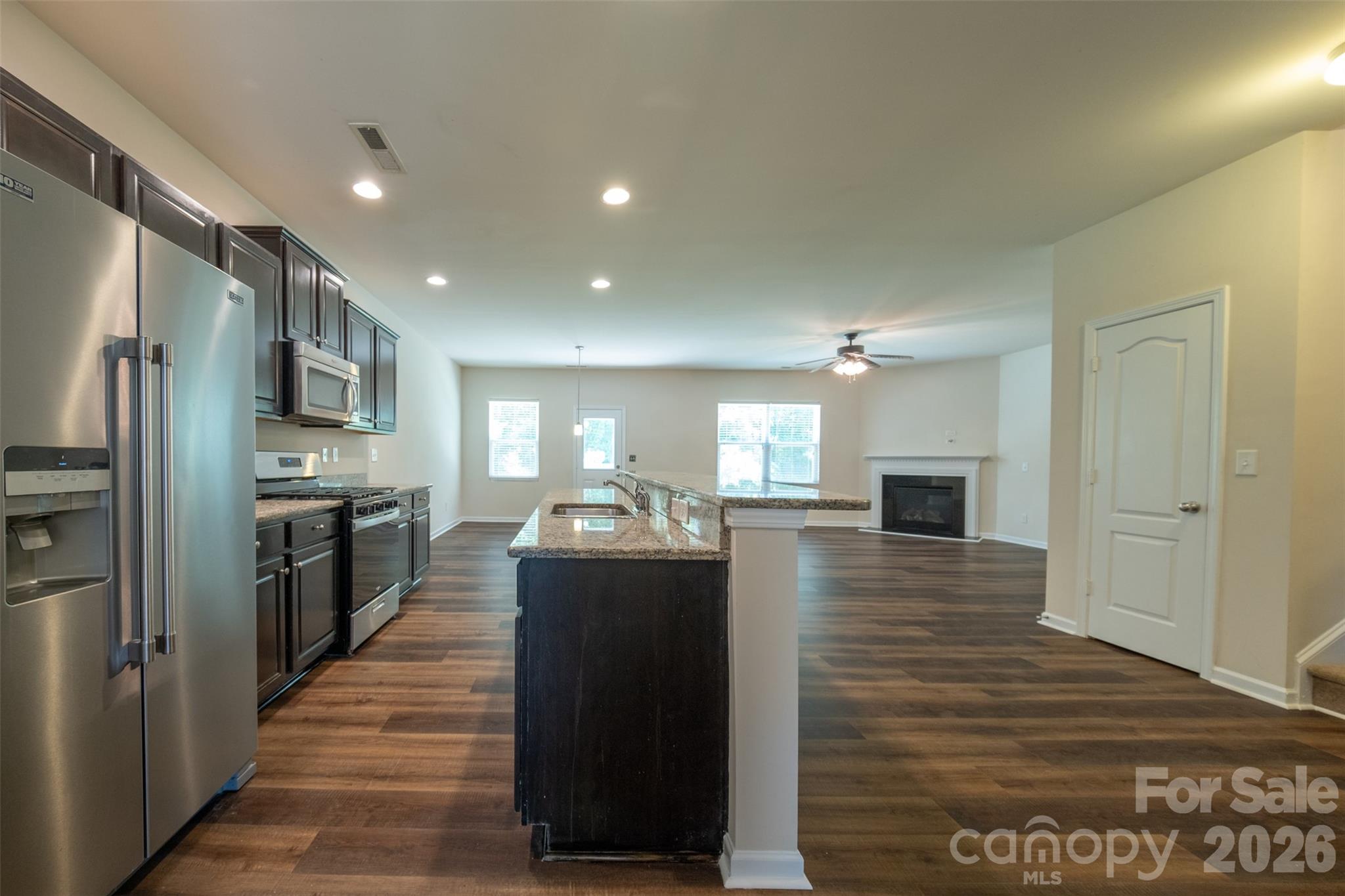 3006 Houndscroft Road Indian Trail, NC 28079 - Photo 13 of 39 a kitchen with stainless steel appliances granite countertop a refrigerator a sink dishwasher and wooden cabinets with wooden floor