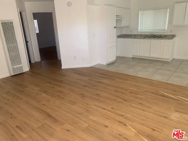 an empty room with wooden floor and cabinets