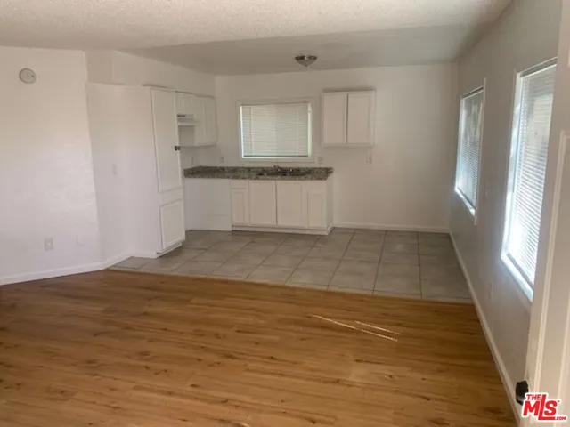 a view of a kitchen with wooden floor and electronic appliances