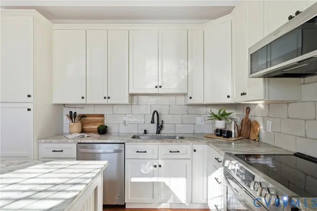 a kitchen with granite countertop a sink a stove and cabinets