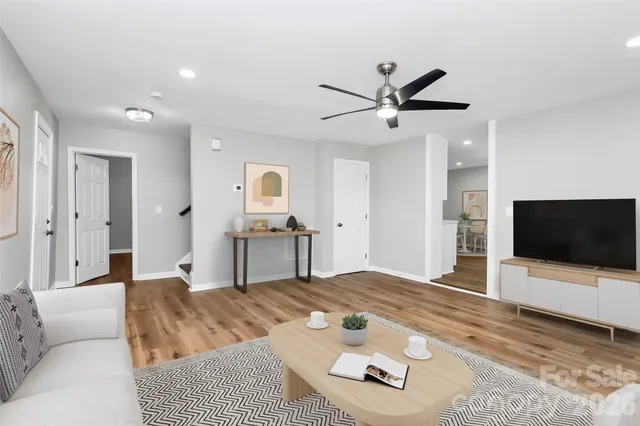 a living room with furniture and a flat screen tv with kitchen view
