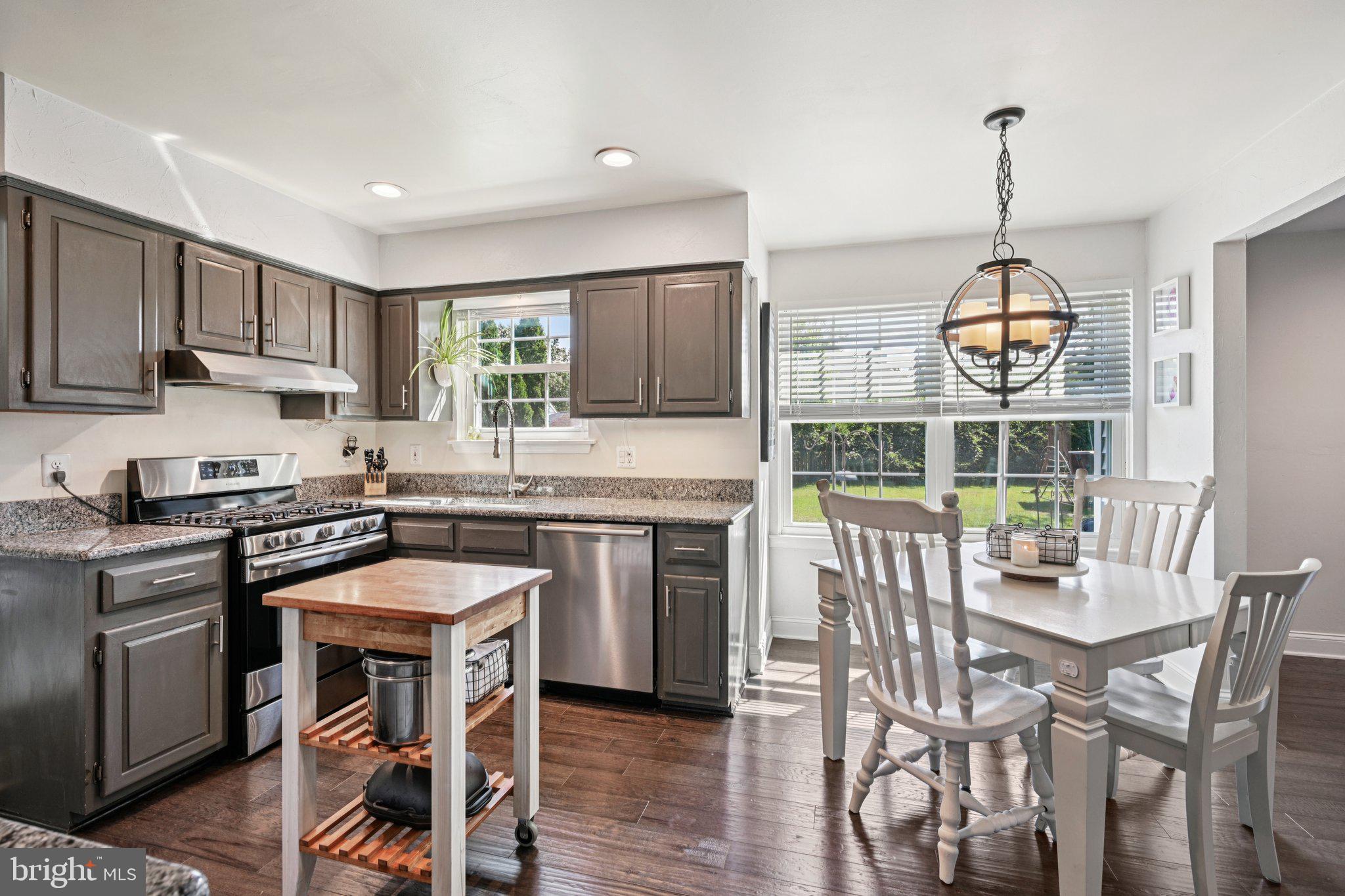 39 Willow Ridge Road Marlton, NJ 08053 - Photo 12 of 43 a kitchen with stainless steel appliances granite countertop a stove top oven a sink dishwasher a dining table and chairs with wooden floor