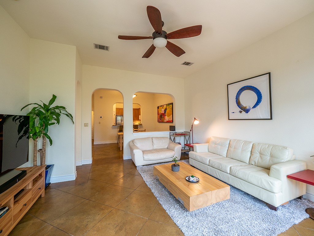 3609 Clawson Road, Unit B Austin, TX 78704 - Photo 5 of 28 Living area featuring a ceiling fan, light-colored walls, arched doorways, and tile flooring