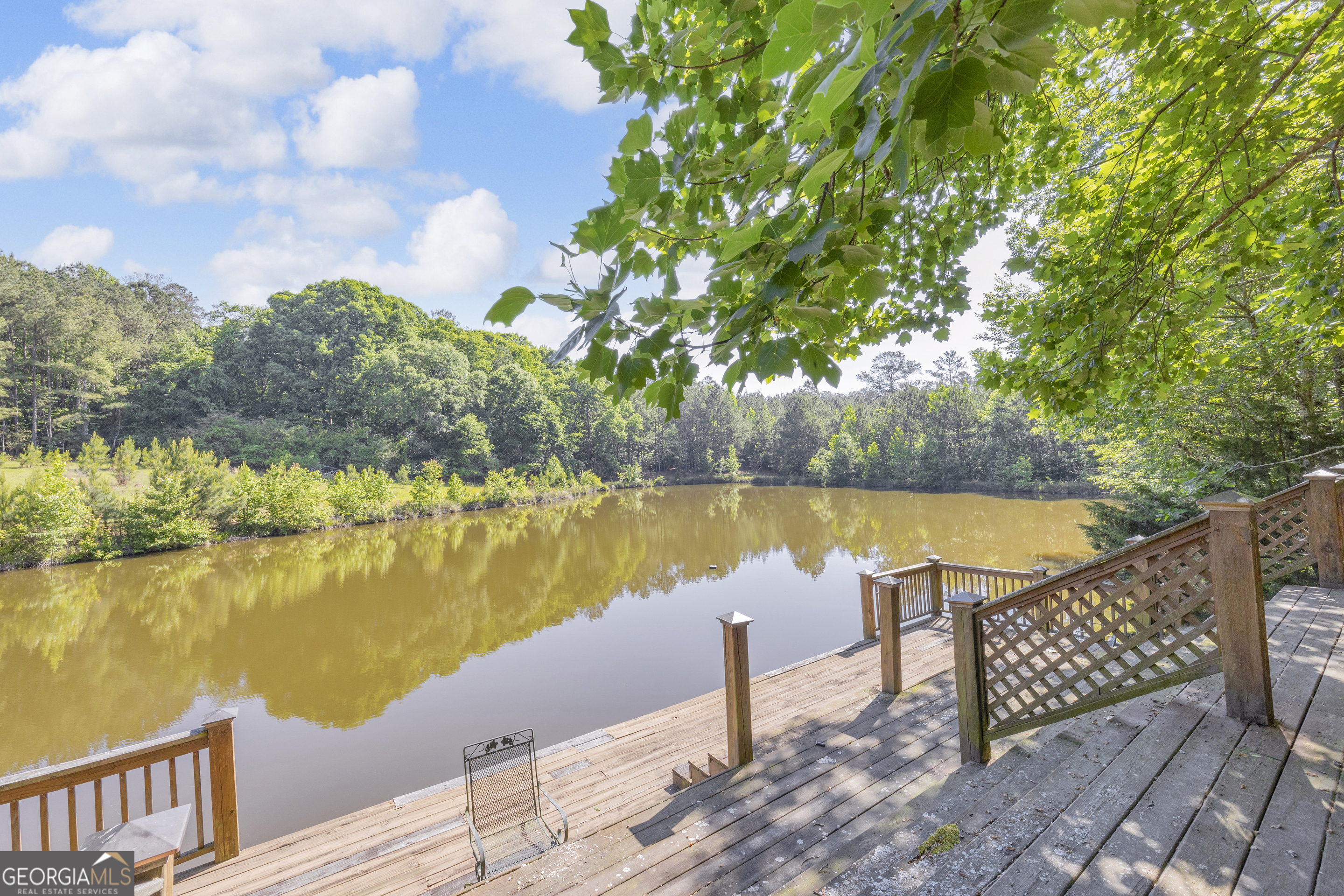 1641 Churchwell Rd Union Point Union Point, GA 30669 - Photo 12 of 48 a view of a lake with couches chairs under an umbrella