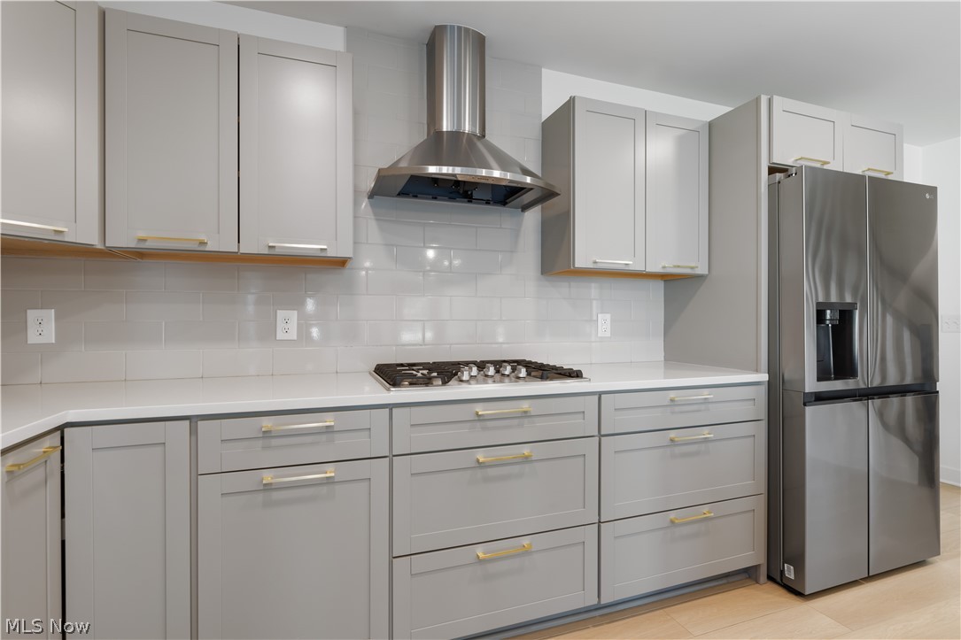 35799 Lorain Road North Ridgeville, OH 44039 - Photo 15 of 50 Kitchen featuring decorative backsplash, stainless steel appliances, wall chimney exhaust hood, and gray cabinets