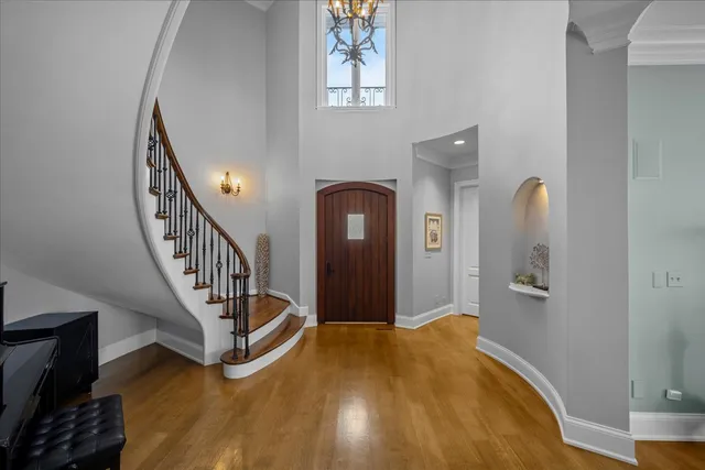 a view of a hallway with wooden floor and staircase