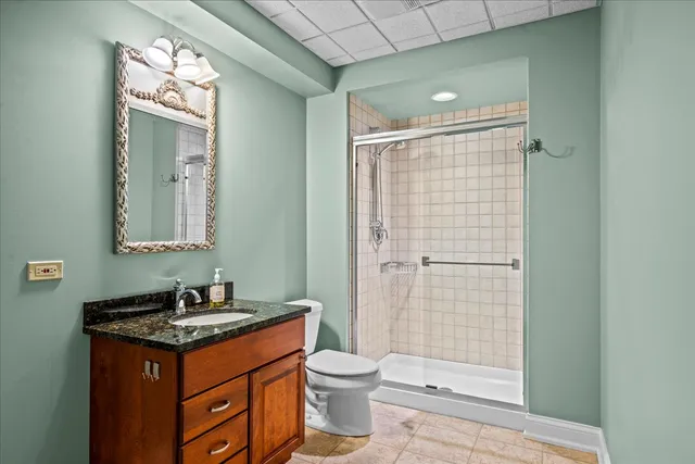 a bathroom with a granite countertop sink toilet a mirror and shower