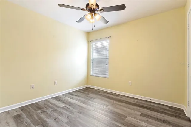 an empty room with a window and a ceiling fan