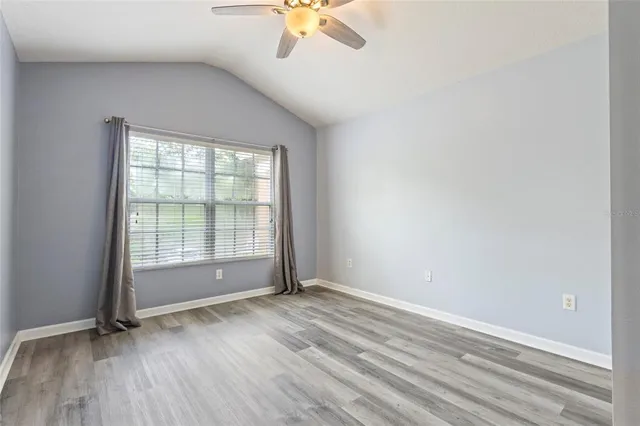 an empty room with a window and a ceiling fan