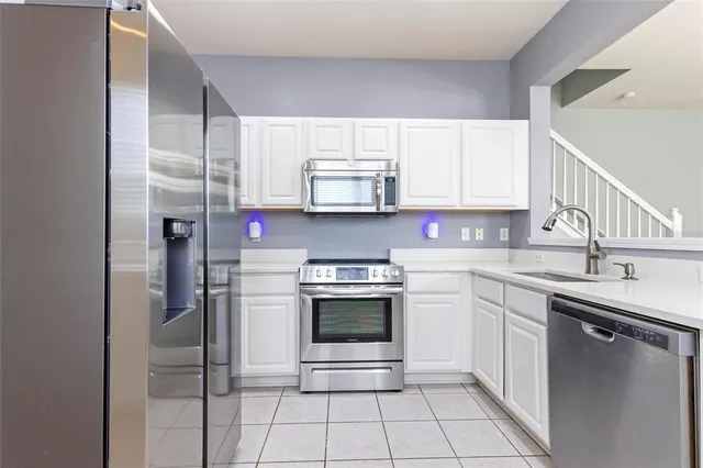 a kitchen with stainless steel appliances granite countertop a sink and a refrigerator