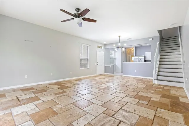 a view of a livingroom with a chandelier fan and a kitchen