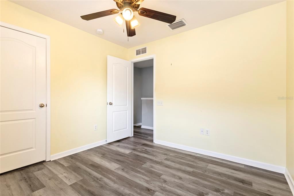 8324 72nd Lane East Bradenton, FL 34201 - Photo 31 of 50 an empty room with wooden floor and a ceiling fan