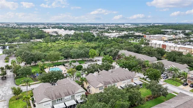 an aerial view of residential house with outdoor space and trees all around
