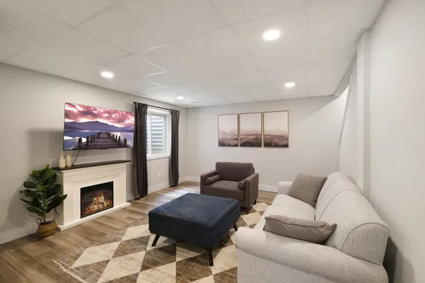 a living room with furniture a flat screen tv and a fireplace