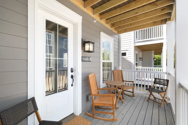 a view of a porch with furniture and wooden floor