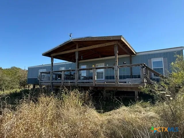 a backyard of a house with wooden deck and barbeque oven