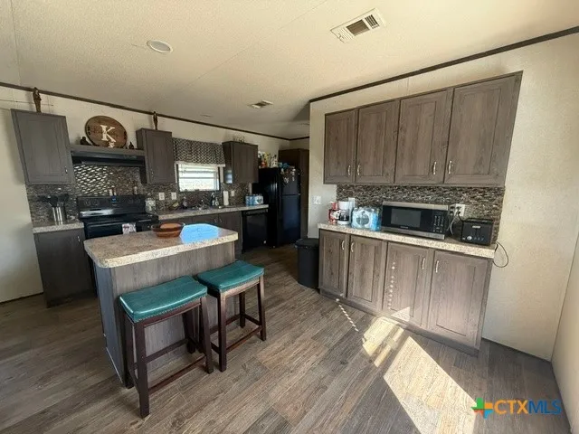 a kitchen with a sink cabinets and wooden floor
