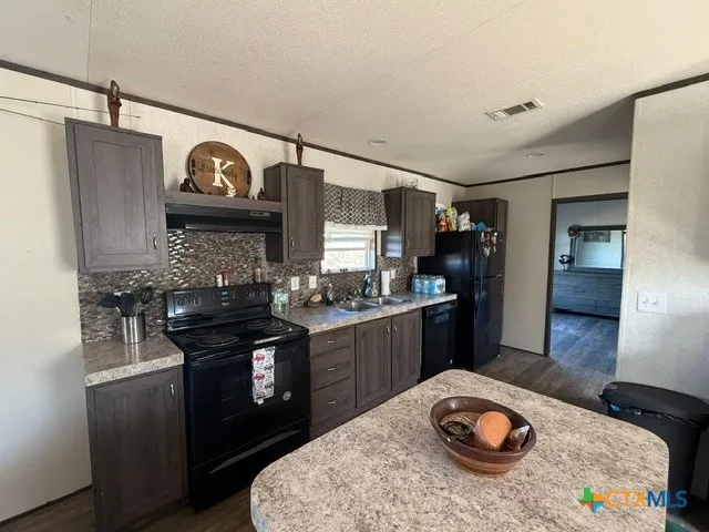 a kitchen with stainless steel appliances granite countertop a sink and a stove